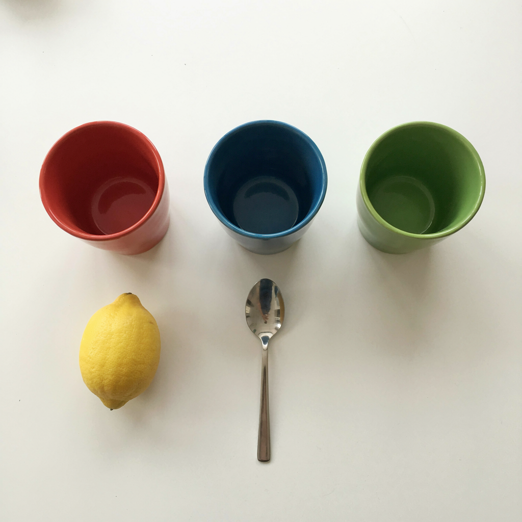 Ideogram 4.0 object-count and placement test with three colored mugs, a lemon, and a teaspoon.